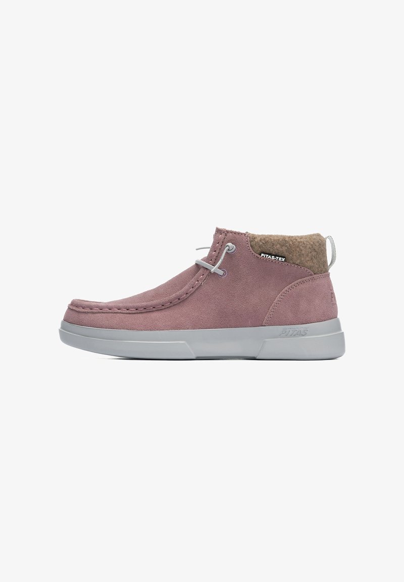 Bottines en suède rose clair avec semelle en caoutchouc gris, bout arrondi et col en feutre. Elles présentent des lacets gris et un logo sur le côté.