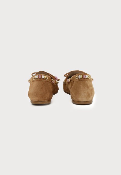 Mocassins en daim marron à bout rond, décorés de perles roses, blanches et dorées le long du bord arrière, montrés de derrière sur fond blanc.