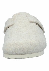 Front view of a beige felt slip-on clog with a wool texture and adjustable strap over the arch, on a white sole.
