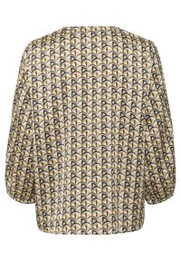 Short-sleeve top featuring a repeating pattern of black, gold, and white fan shapes on a light background with a relaxed fit.