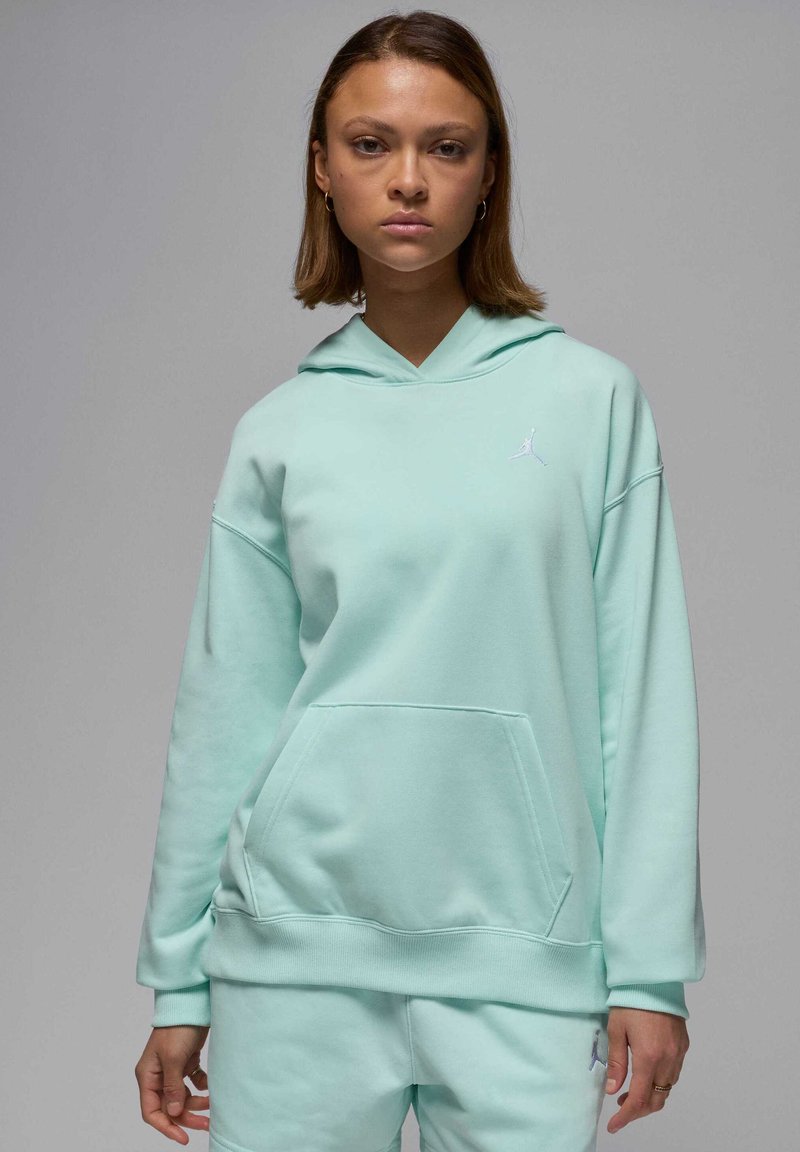 Sudadera verde menta hecha de tela suave, con un bolsillo frontal, puños acanalados y un logo discreto en el pecho. Diseño con capucha y corte relajado.