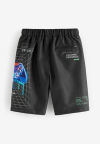 Schwarze Shorts aus glattem Stoff zeigen auf der Rückseite eine bunte Grafik eines Gamecontrollers und grüne Schrift mit Gaming-Statistiken. Sie sind mit einem elastischen Bund ausgestattet.
