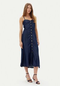 Abito in denim con corpino aderente, spalline sottili e chiusura frontale con bottoni. L'abito ha una lunghezza midi fluida e una tonalità di blu intenso.
