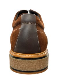 Chaussure en daim marron avec un contrefort en cuir foncé, des détails cousus et une semelle en caoutchouc texturée. Vue arrière mettant en avant les éléments de design.