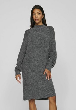 Vestido de punto gris de gran tamaño con un alto escote, mangas largas, textura de canalé y aberturas laterales en el dobladillo para mayor movilidad.