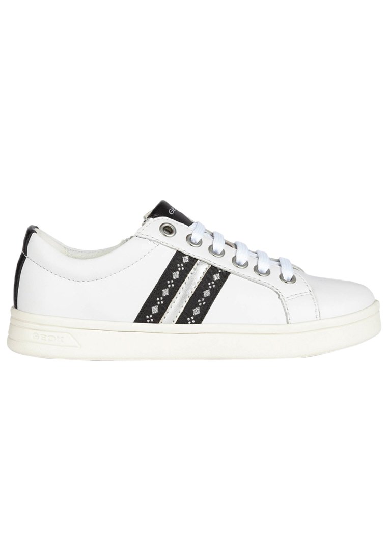 Zapatilla de cuero blanco con rayas negras que presenta patrones decorativos, puntera redonda, suela blanca y detalles en negro contrastantes en el talón.