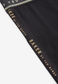 Fekete szövetruha, arany logóval, "BAKER by TED BAKER" felirattal az élein, sima textúrával.