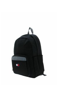 Sac à dos noir avec structure rembourrée, poche avant grise, bretelles réglables et étiquette logo. Comprend une poignée supérieure et des poches latérales en mesh.