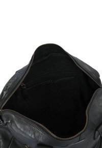 Zwarte leren tas met een ritssluiting. De binnenkant is gevoerd met zwarte stof en beschikt over een ritsvak en organisatievakjes.