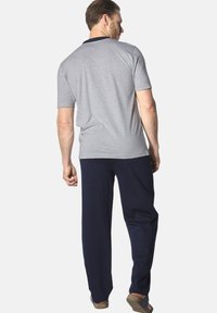 Gray short-sleeve shirt with a navy collar, paired with navy pants. Smooth fabric texture, relaxed fit, and simple design.