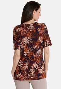 Bloemmotief top met korte mouwen, met een mix van bordeauxrood, oranje en crèmekleurige tinten op een donkere achtergrond. Zachte, rekbare stof.