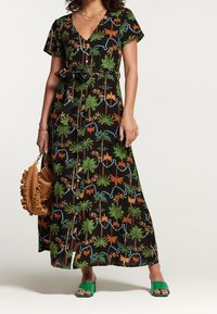 Svart maxiklänning med v-ringning, korta ärmar, blommönster i grönt, orange och blått. Inkluderar ett knytbälte och knapprader.