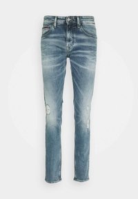 Jean en denim bleu clair à coupe slim, avec des détails usés aux genoux et un design classique à cinq poches, fini par une ceinture à passants.