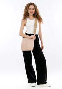 Borsa a spalla in pelle rosa chiaro con una finitura testurizzata, una tracolla larga beige e un design minimalista. Presenta una chiusura superiore con zip.