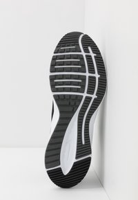 Zwart-witte sneakerzool, met een textuur van rubberen buitenzool met een zigzagpatroon en opvallende groeven voor grip.