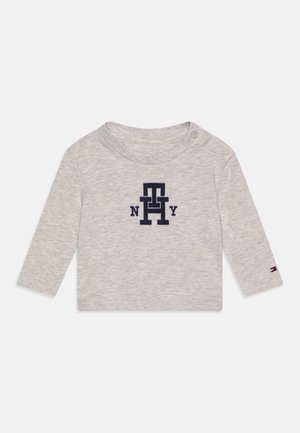 Lysegrå langærmet babytrøje med navy "TH NY" logo foran og lille flagdetalje på venstre ærmekant.