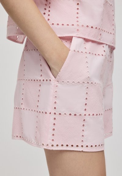 Pantaloni corti intrecciati rosa con un motivo a quadri, dettagli a taglio e una tasca inserita. Il materiale presenta una finitura testurizzata.