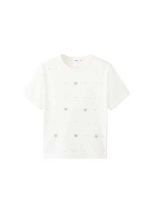 T-shirt en coton blanc à manches courtes, avec une broderie florale argentée et de petits éléments décoratifs espacés uniformément sur le devant.