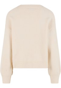 Svetre krémovej farby s mäkkou textúrou, s krátkym strihom, rebrovaným lemom a spustenými švami na ramenách. Bez vzorov alebo kovových doplnkov.