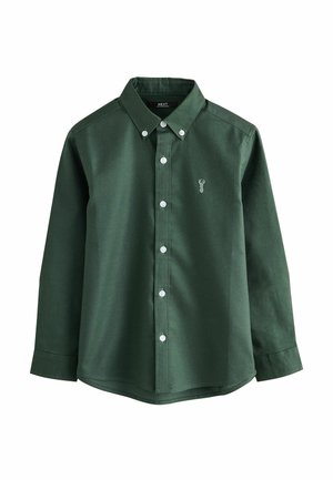 Chemise verte à manches longues avec col boutonné, boutons blancs et un emblème de cerf sur la poitrine. Fabriquée en tissu coton texturé.