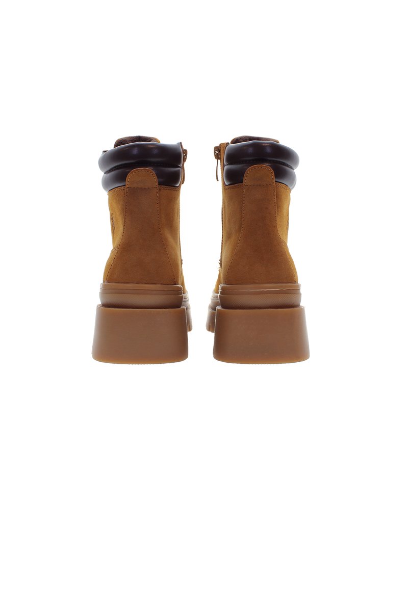 Stivaletti ankle in suede marrone con un colletto imbottito nero e suola spessa marrone. Presenta una chiusura con cerniera sul lato per una facile calzata.