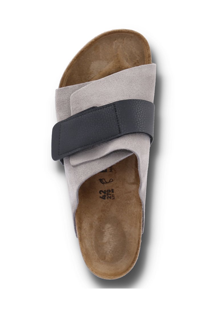 Grau Veloursleder Sandale mit einem schwarzen strukturierten Riemen. Vorgeformtes Fußbett und minimales Design. Größenmarkierungen auf der Innensohle sichtbar.