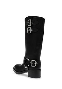Stivali in pelle nera al ginocchio con fibbie argentate sul lato, tacco spesso e superficie liscia. Presentano una tracolla decorativa per la caviglia.