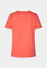 Camiseta de manga corta en color coral, hecha de una tela suave. Cuenta con un cuello redondo clásico y un corte relajado con un dobladillo recto.