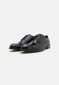 Zapatos de vestir de charol negro con un acabado suave, punta redondeada y un diseño clásico de cordones. Detalles de costura sutil en la parte superior.