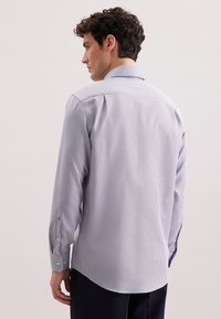Camicia a maniche lunghe in un motivo a quadri lilla e bianco, con colletto classico e polsini bottone, realizzata in tessuto morbido.