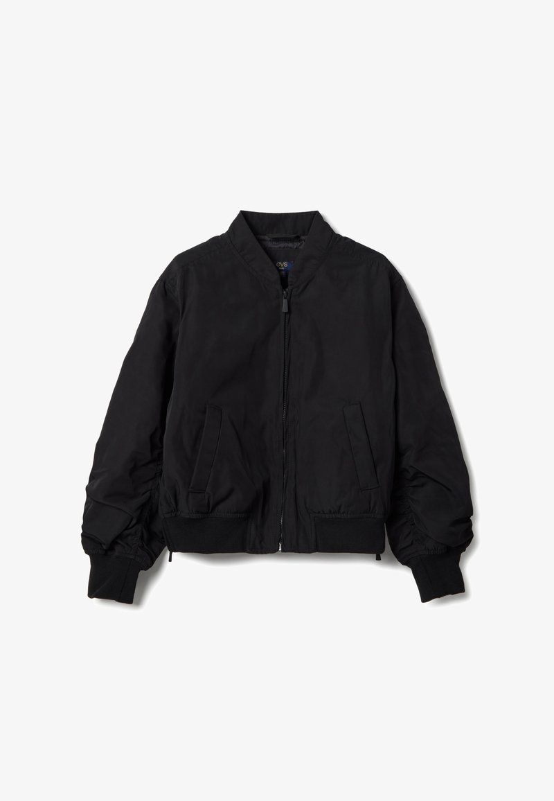 Chaqueta bomber negra con cremallera frontal, puños y borde inferior acanalados, y dos bolsillos delanteros inclinados, extendida sobre un fondo blanco.