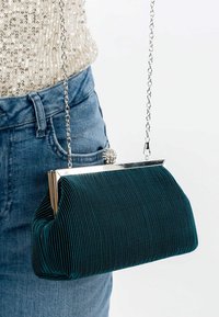 Borsa a pochette plissettata color teal con telaio metallico e chiusura in cristallo, dotata di una tracolla in catena argentata. Il tessuto testurizzato aggiunge profondità al design.