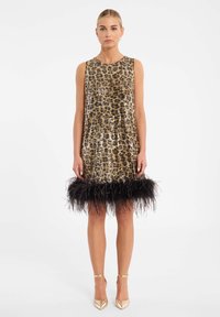 Robe à paillettes en or et noir avec un motif léopard. Dotée d'un ourlet en plumes noires. Sans manches, de design évasé avec un col rond.