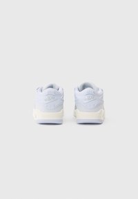 Un paio di sneaker Nike Air bianche e grigio chiaro viste da dietro su uno sfondo bianco uniforme.