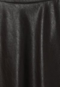 Tissu en cuir synthétique noir avec une texture lisse, légèrement brillante. Présente des variations subtiles de brillance, réfléchissant la lumière. Convient à divers vêtements.