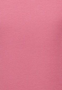 Tissu rose côtelé avec des lignes verticales, texture lisse et motif uniforme. Le matériau semble léger et extensible.