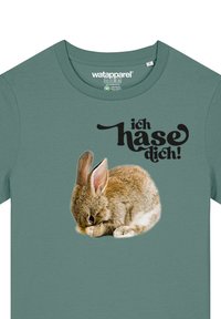 Grünes Baumwoll-T-Shirt mit einer Grafik eines sitzenden braunen Hasen und dem Text "ich hasse dich!" in fetter schwarzer Schrift.