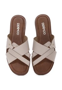 Sandales à glissière beiges avec des brides croisées, supérieure en simili cuir, semelle intérieure texturée marron et marquage discret sur le coussinet.