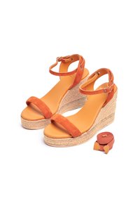 Sandales compensées en daim orange avec une semelle en jute, dotées d'une large bride avant et d'une bride de cheville à boucle. Comprend une sangle en tissu assortie.