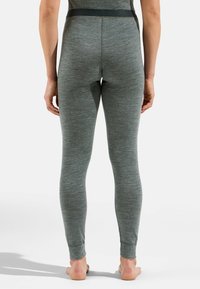 Graue, eng anliegende Leggings aus einem weichen, strukturierten Stoff mit einem breiten schwarzen Bund. Das Design umfasst taillierte Bündchen an den Knöcheln.