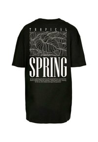 Sort t-shirt med et hvidt grafisk design omfattende tropiske blade og ordet "FORÅR" i fed, stor skrift. Korte ærmer, afslappet pasform.
