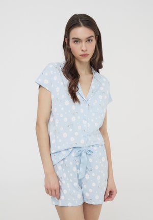 Set di pigiama azzurro chiaro composto da una maglietta maniche corte e pantaloncini, decorato con margherite bianche e api, con un dettaglio di vita con lacci.