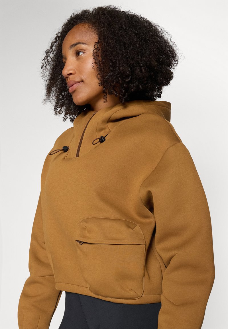 Braun geschnittenes Kapuzensweatshirt mit einer Fronttasche, verstellbaren Kordeln und einer glatten Textur. Verfügt über einen Reißverschluss-Taschendetail.
