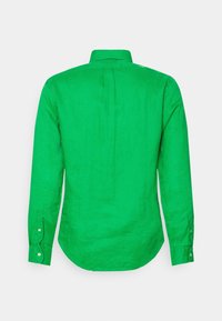 Grön linne skjorta med långa ärmar, knäppning vid handleden, en rynka i ryggen och rundad nederkant. Slät textur och livfull färg.