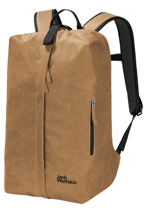 Sac à dos en toile cirée marron avec une poche zippée à l'avant, des bretelles noires réglables et une fermeture en haut. Présente un logo de marque sur le côté.