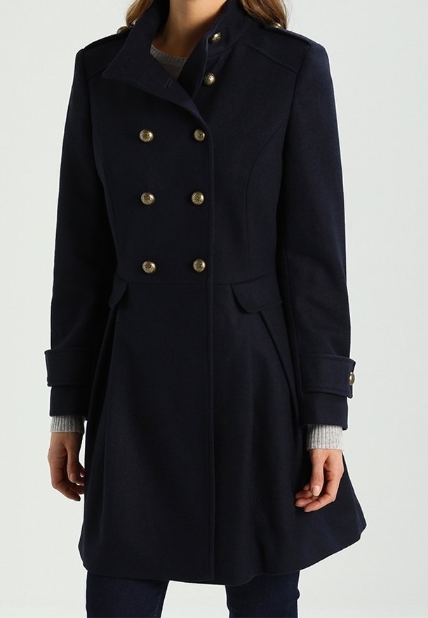 Abrigo de lana azul marino con cuello alto, diseño de doble botonadura, botones en tono dorado, bolsillos laterales y silueta estructurada. Mangas largas con puños.