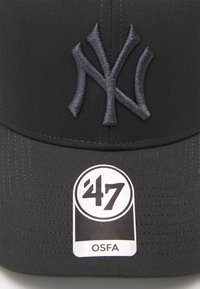 Căciulă neagră cu un logo brodat de culoare gri închis "NY" în față, având un eticheta circulară care afișează "47" și "OSFA". Suprafață din material texturat.