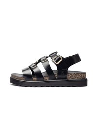 Sandal de cuero negro con tres correas anchas, hebilla ajustable y plantilla de corcho texturizado. Presenta una suela de goma con dibujo de zigzag.