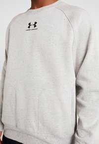 Felpa grigia chiara con una texture a macchie, con logo Under Armour nero sul petto e colletto e polsini a costine.