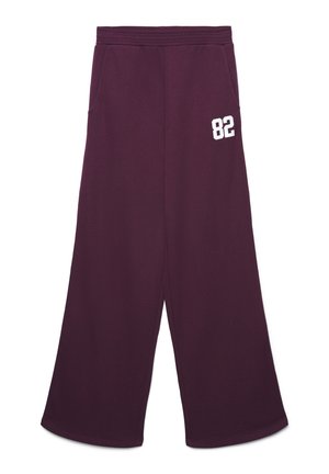 Pantaloni ampi in felpa viola con vita elastica, tasche laterali e la scritta bianca "82" stampata sulla coscia superiore.